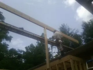 Carpenter setting a ridge beam over a new addition frame — Ice Dam Removal by Roofing Brothers in Huntingdon Valley
