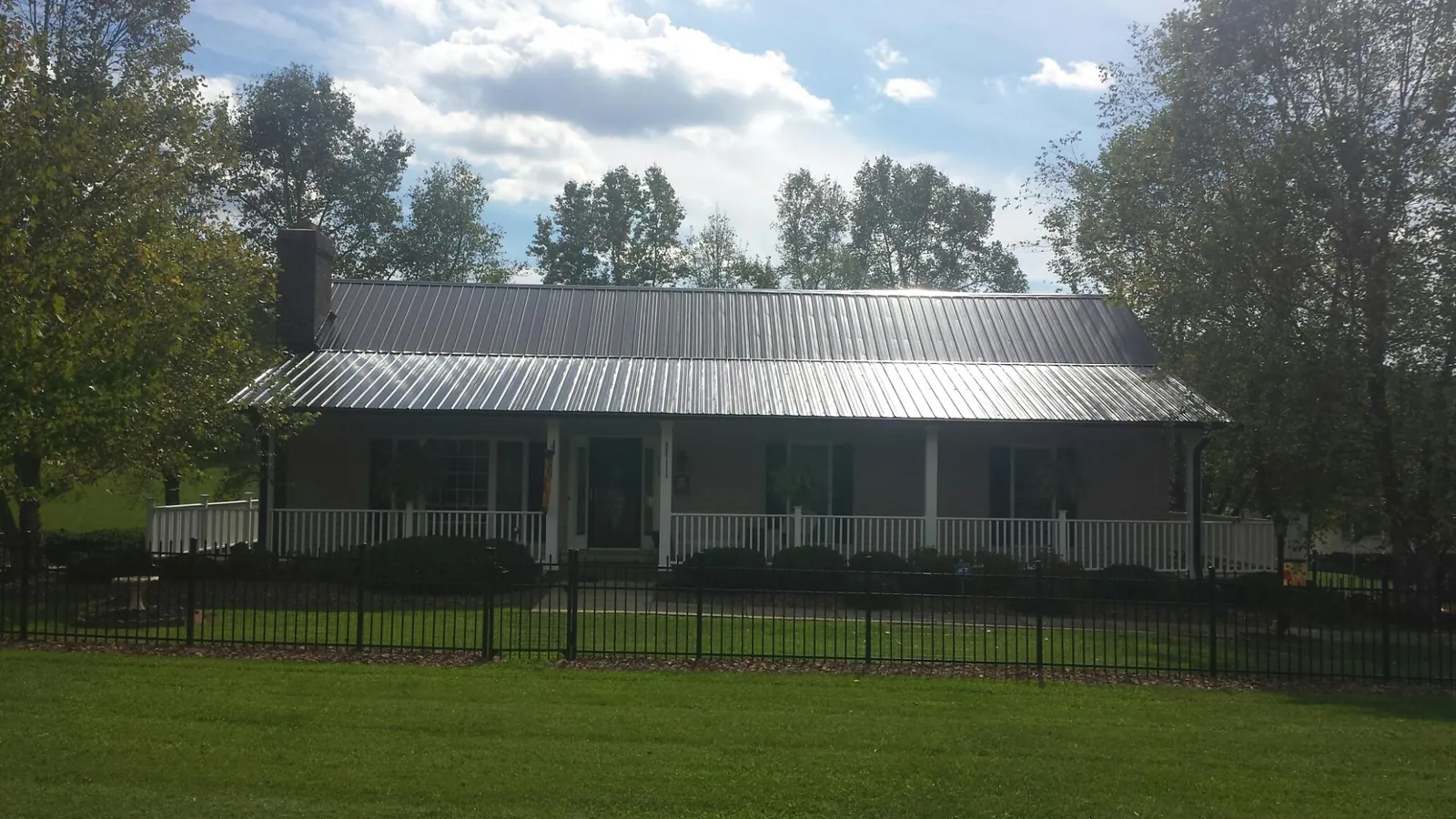 Gray metal roof on a brick ranch with a full width front porch — Gutter Guard Installation work by our crew in Huntingdon Valley