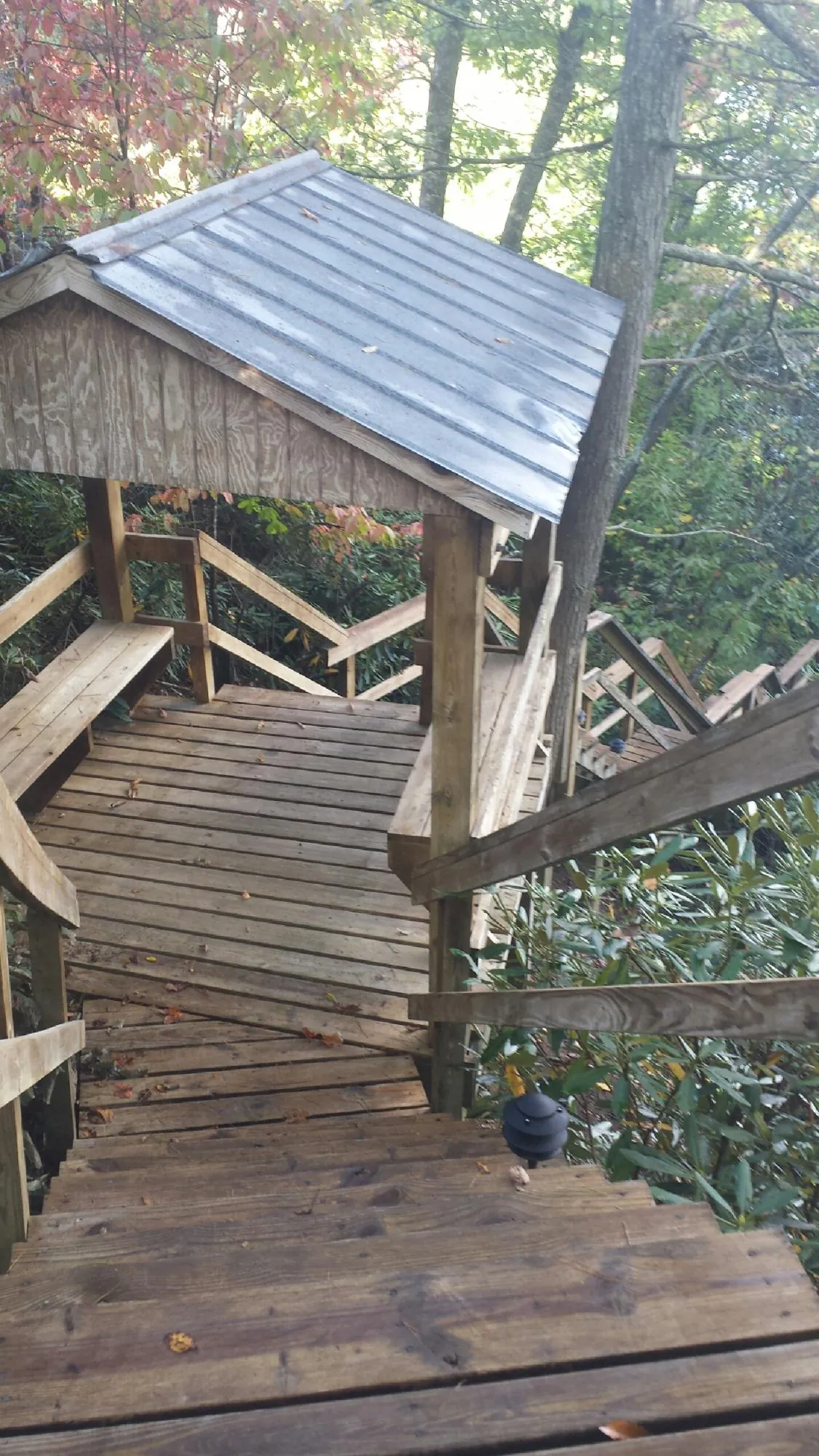 Metal roofed shelter over wooden steps on a wooded walkway — Skylight Repair & Installation work by our crew in Huntingdon Valley